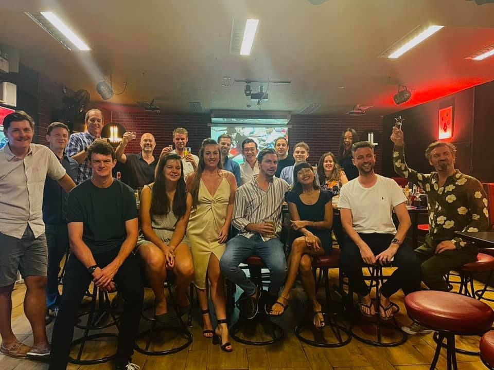 A group of people are posing for a picture in a bar.