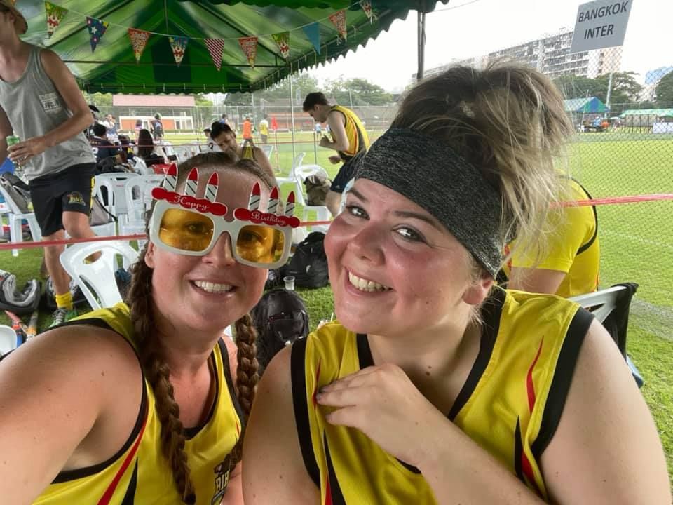 Two women wearing sunglasses and a headband are posing for a picture.