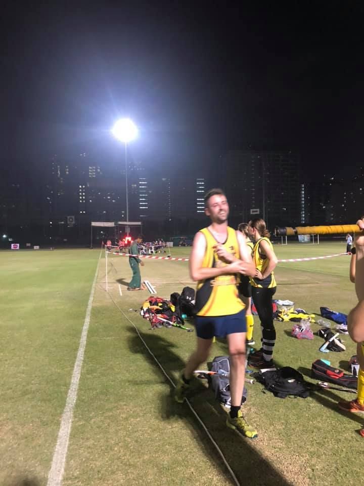 A group of people are standing on a field at night.