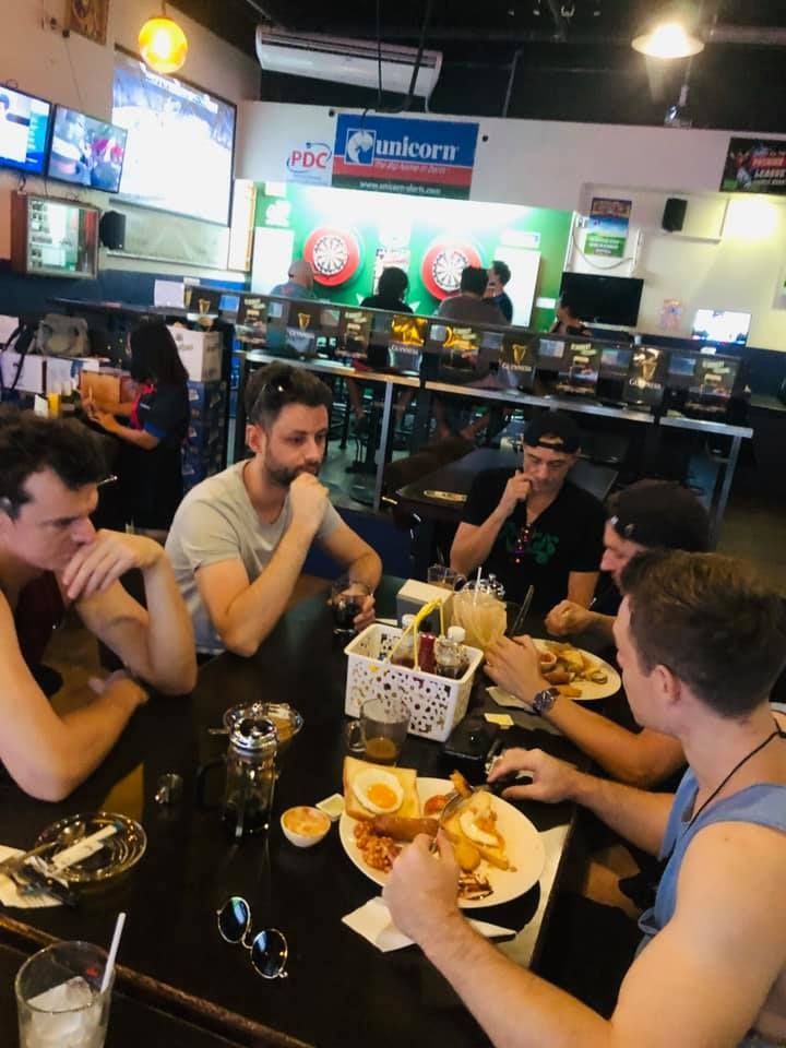 A group of men are sitting at a table in a restaurant eating food
