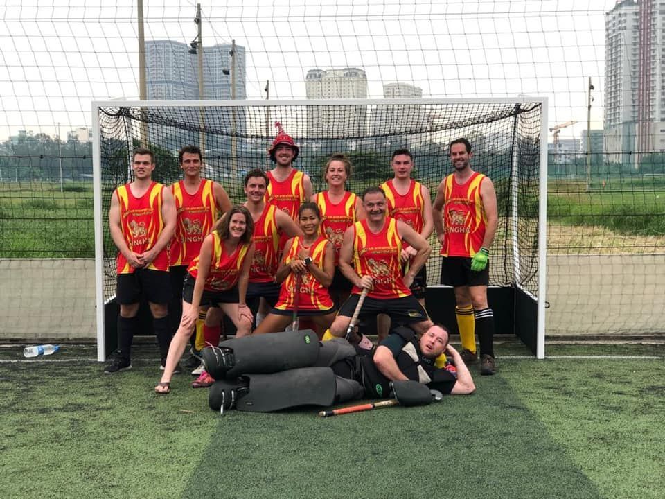 A group of people are posing for a picture on a field.