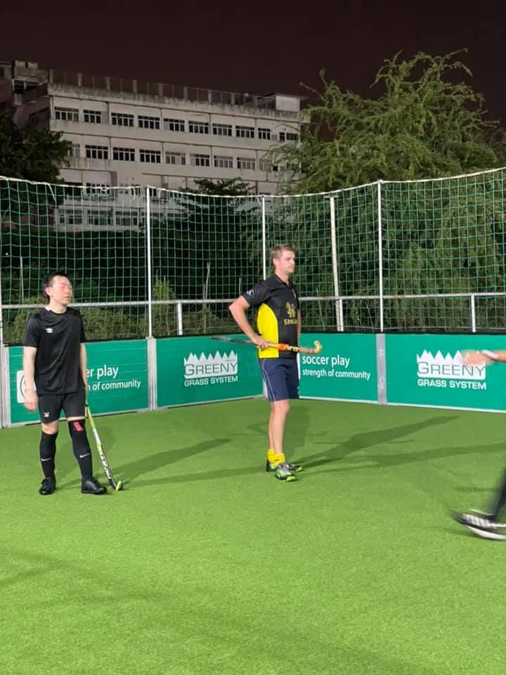 A group of men are playing soccer on a field at night.