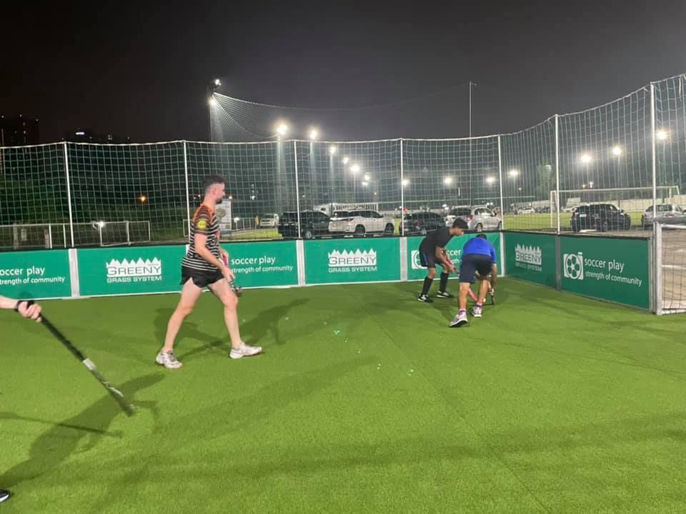 A group of people are playing a game of soccer on a field at night.
