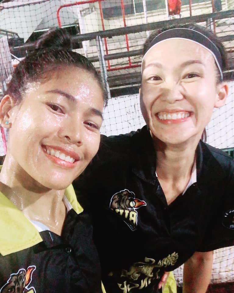 Two women are posing for a picture and one of them is wearing a shirt that says ' tiger ' on it