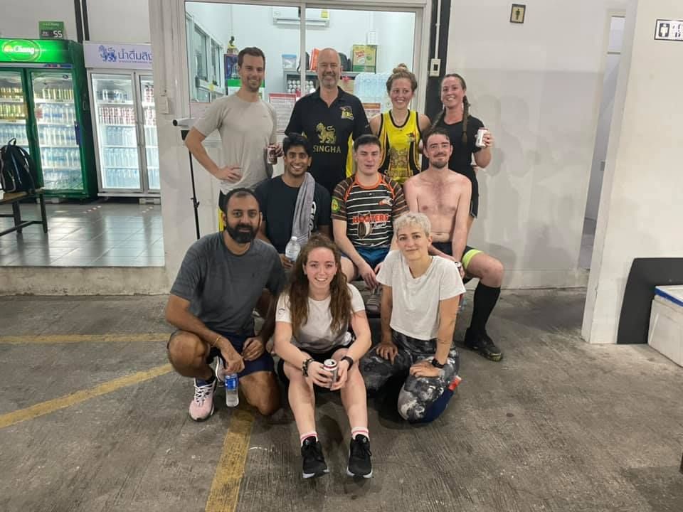 A group of people are posing for a picture in a parking lot.