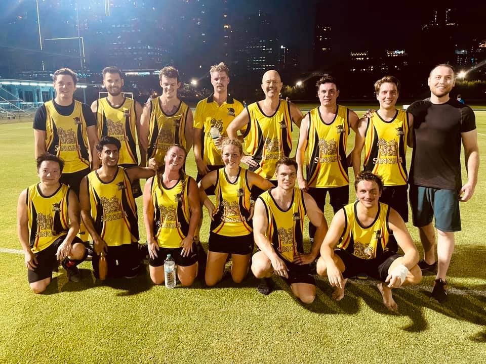A group of people are posing for a picture on a field.