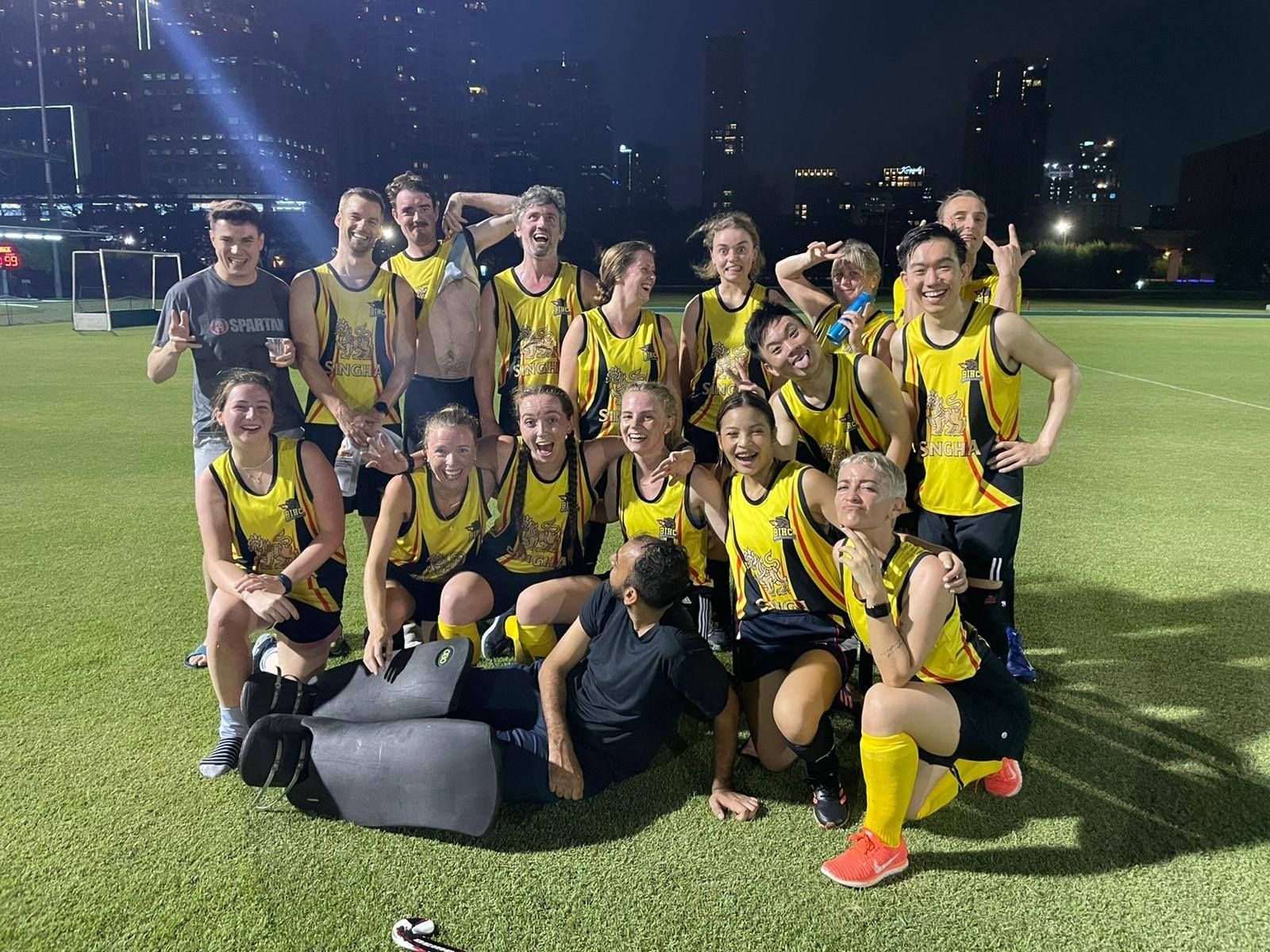 A group of people are posing for a picture on a field.