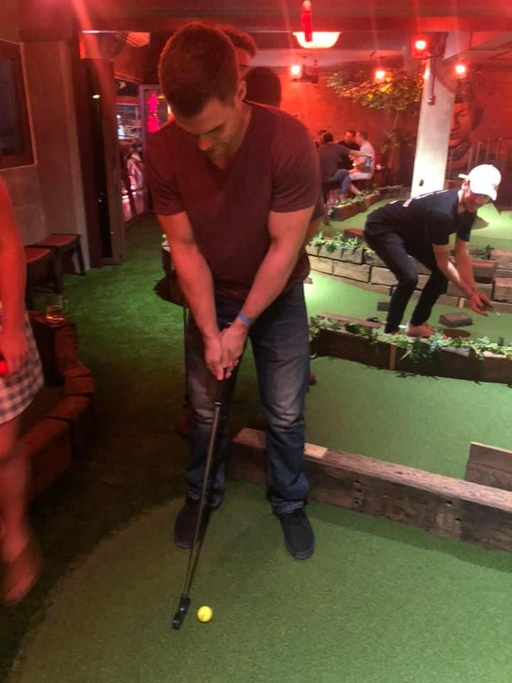 A man is playing a game of mini golf