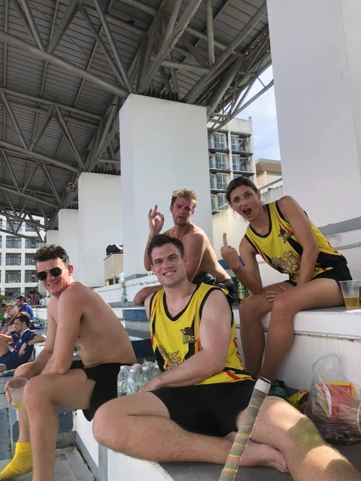 A group of people are sitting on a bench in a stadium.