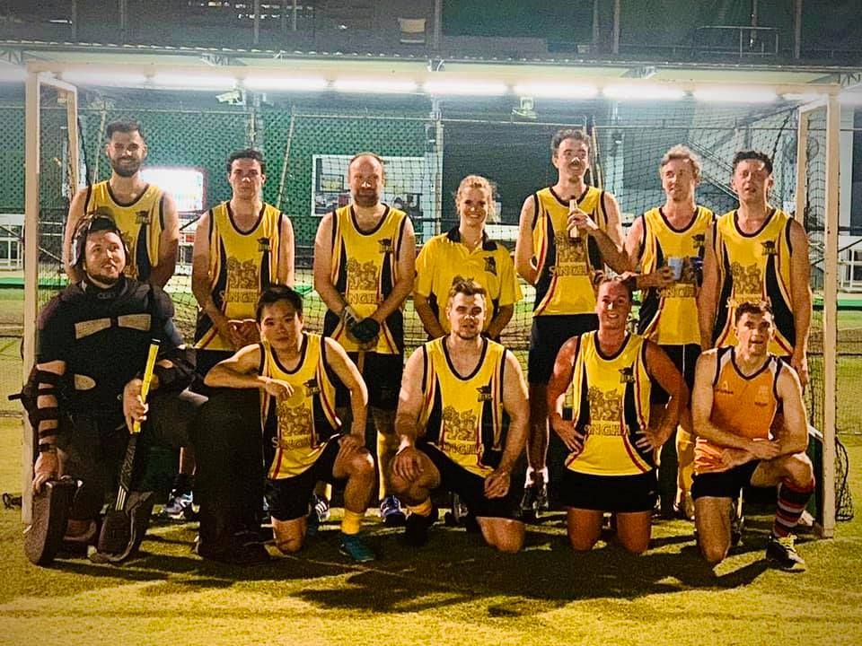 A group of people are posing for a picture on a field.