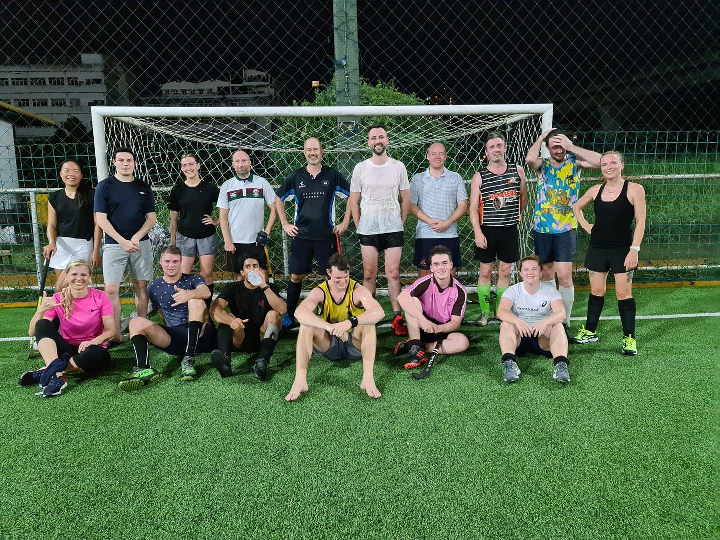 A group of people are posing for a picture on a soccer field.