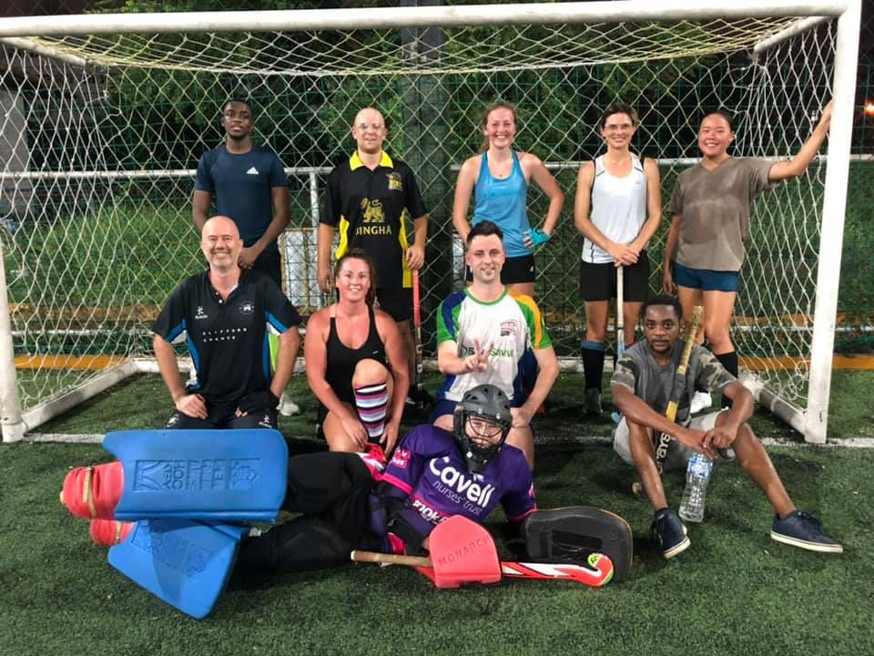 A group of people are posing for a picture in front of a soccer goal.
