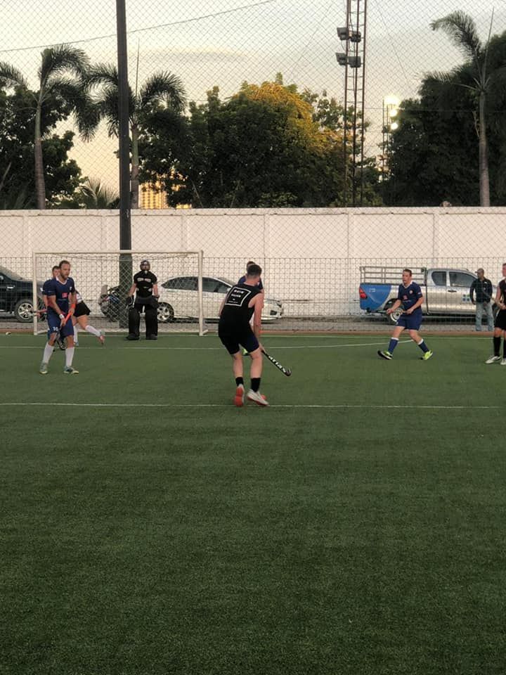A group of people are playing a game of field hockey on a field.