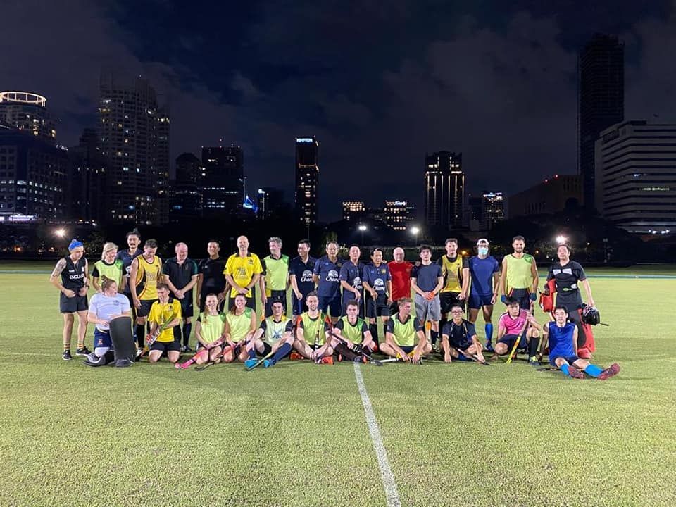 A group of people are posing for a picture on a field at night.