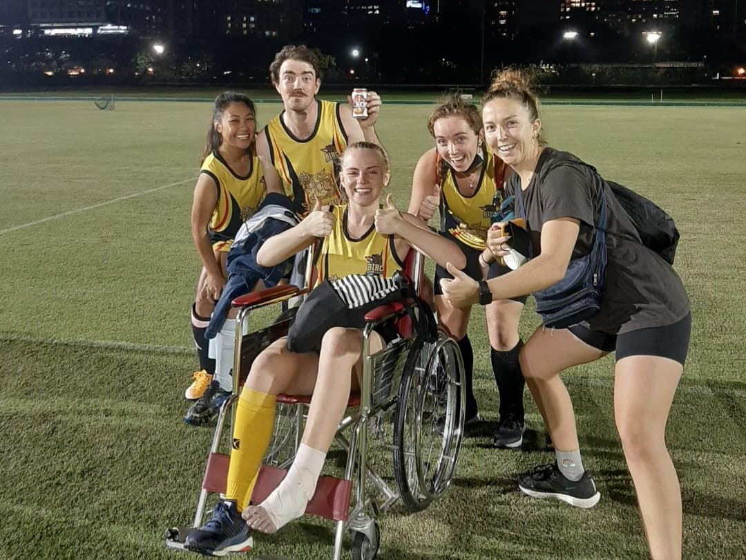 A group of people are posing for a picture with a man in a wheelchair.