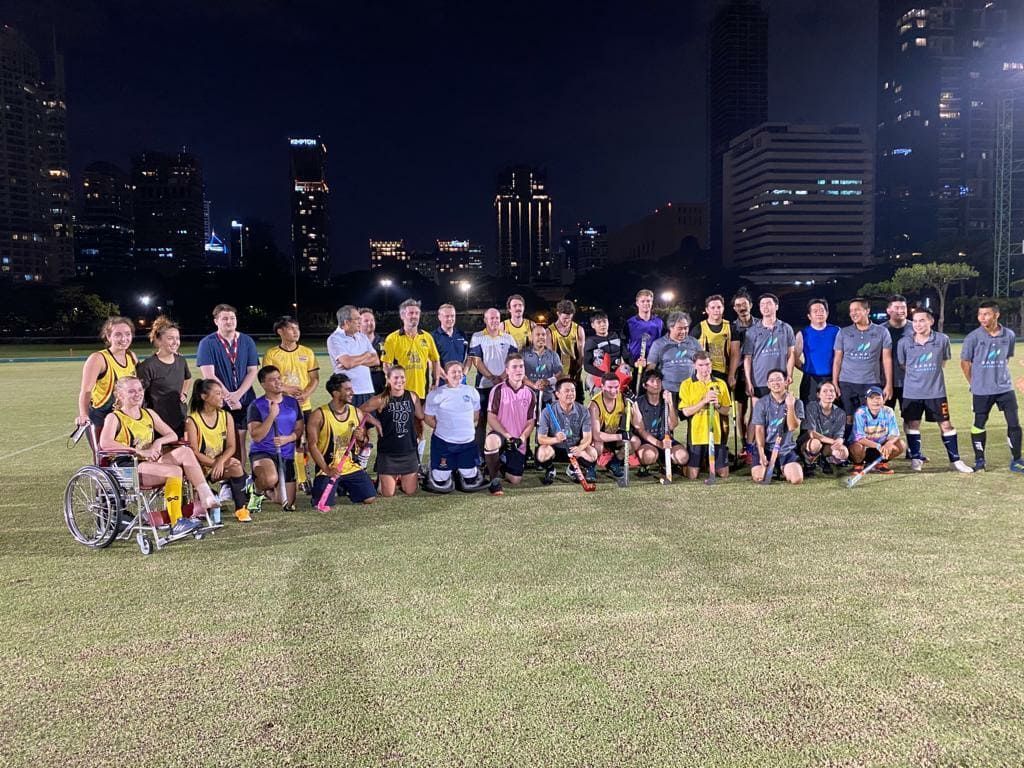 A group of people are posing for a picture on a field at night.