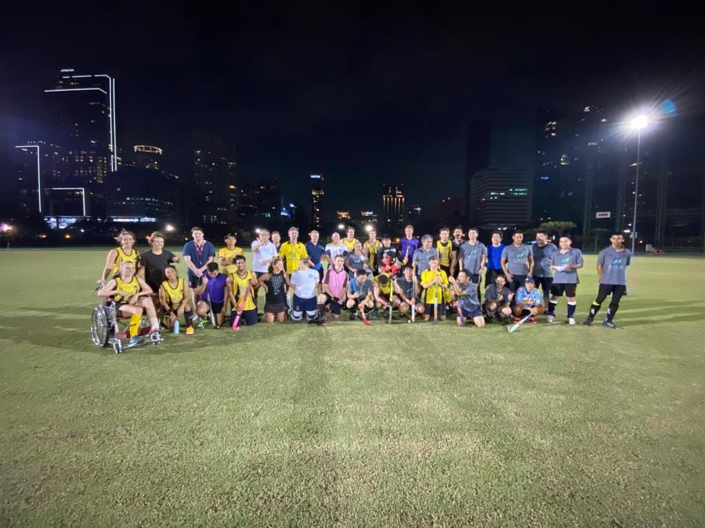 A group of people are posing for a picture on a field at night.