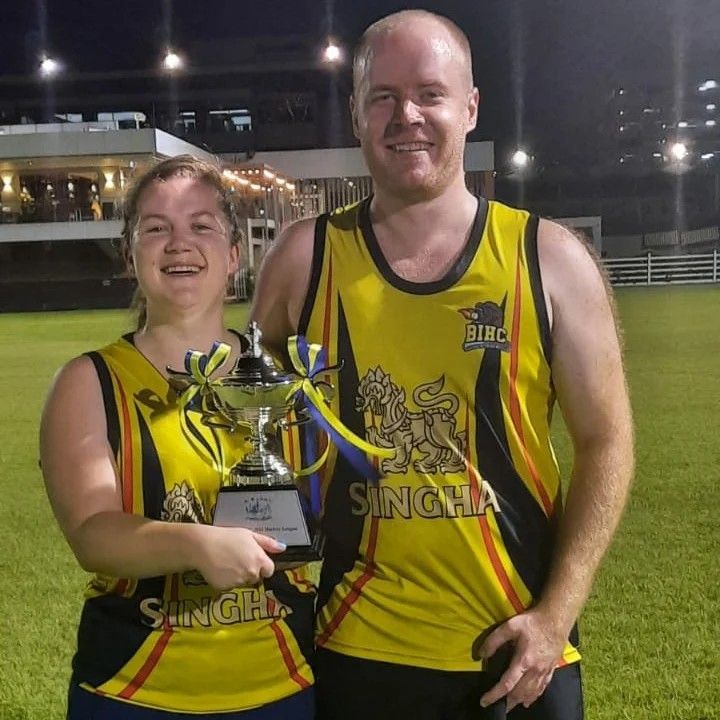 A man and a woman holding a singha trophy