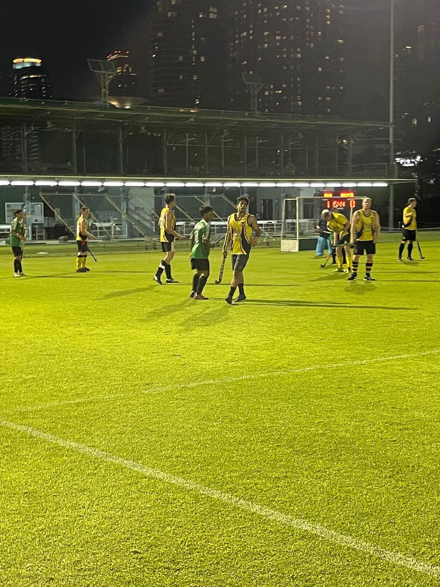 A group of people are playing soccer on a field at night.