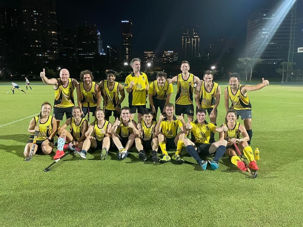 A group of people are posing for a picture on a field.