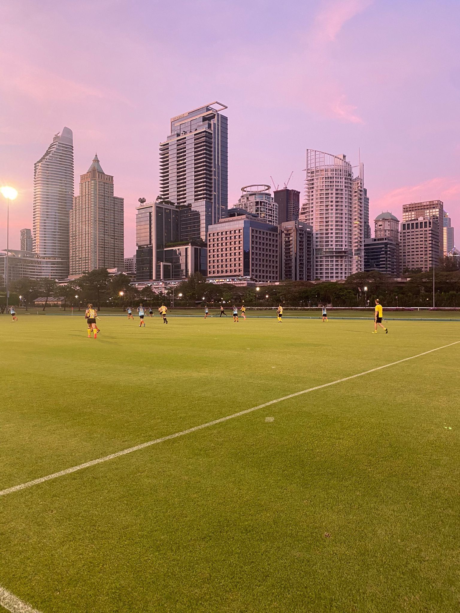 A soccer field with a city skyline in the background