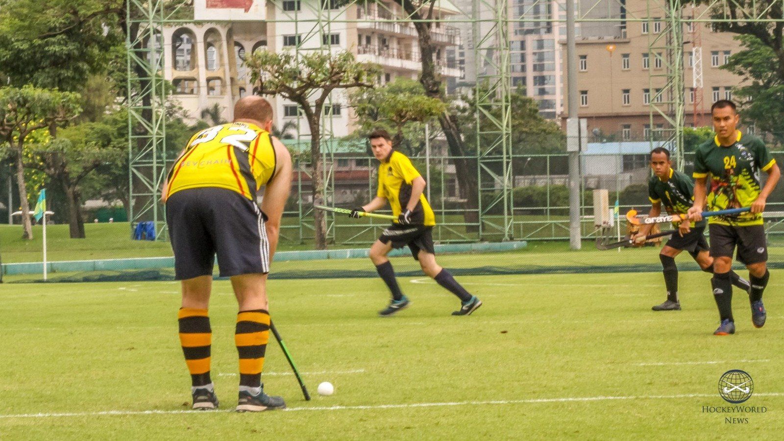 A group of men are playing field hockey on a field