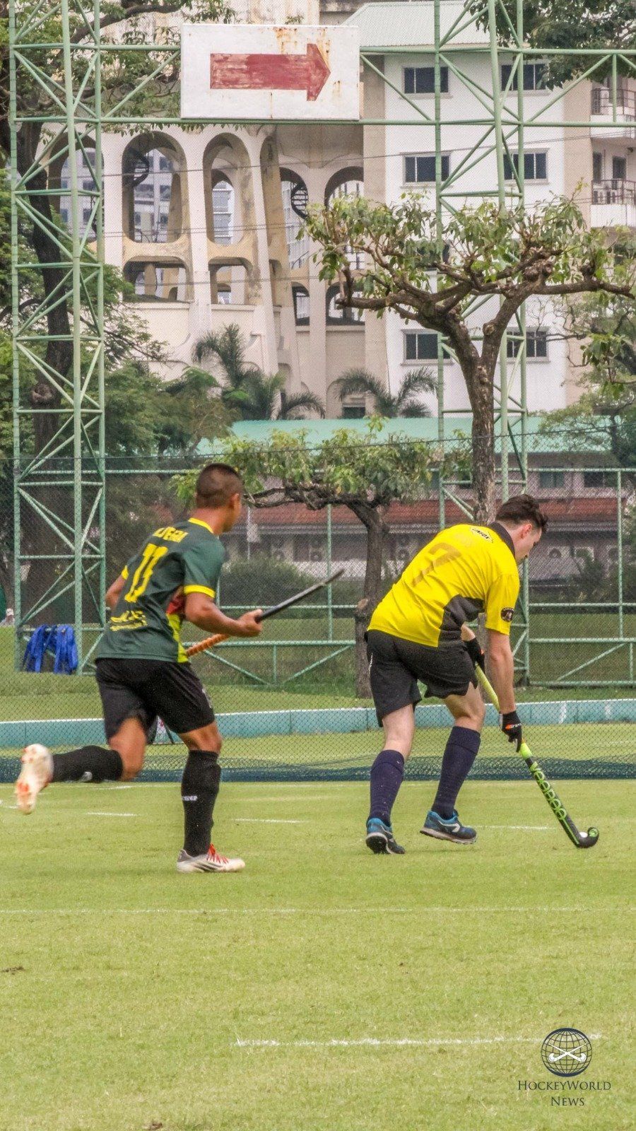 Two men are playing field hockey on a field.