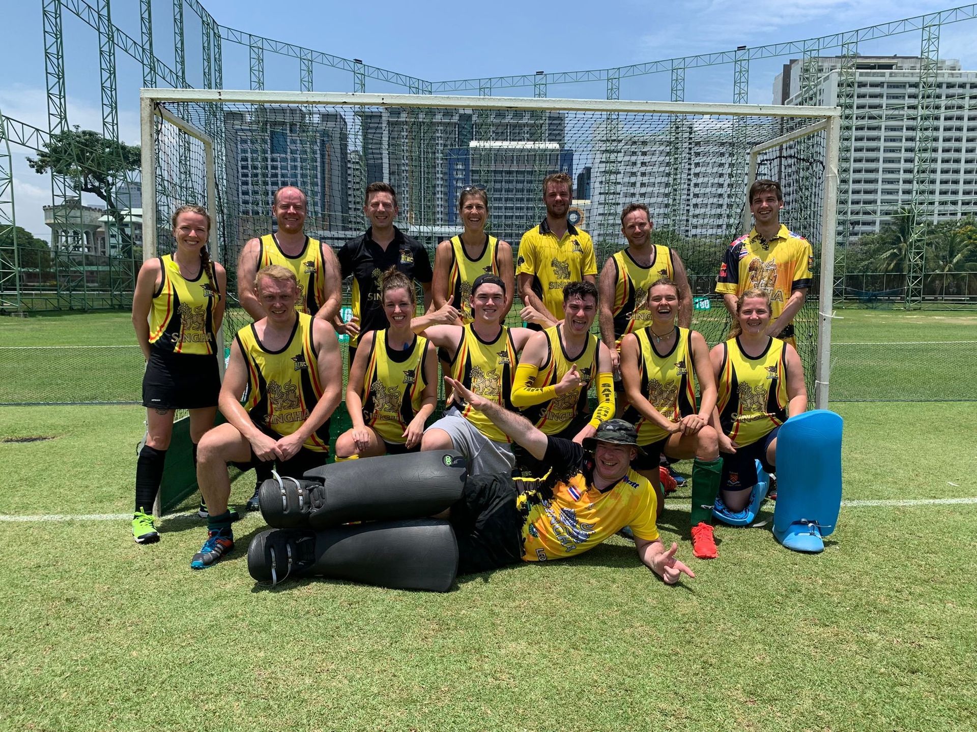 A group of people are posing for a picture on a soccer field.