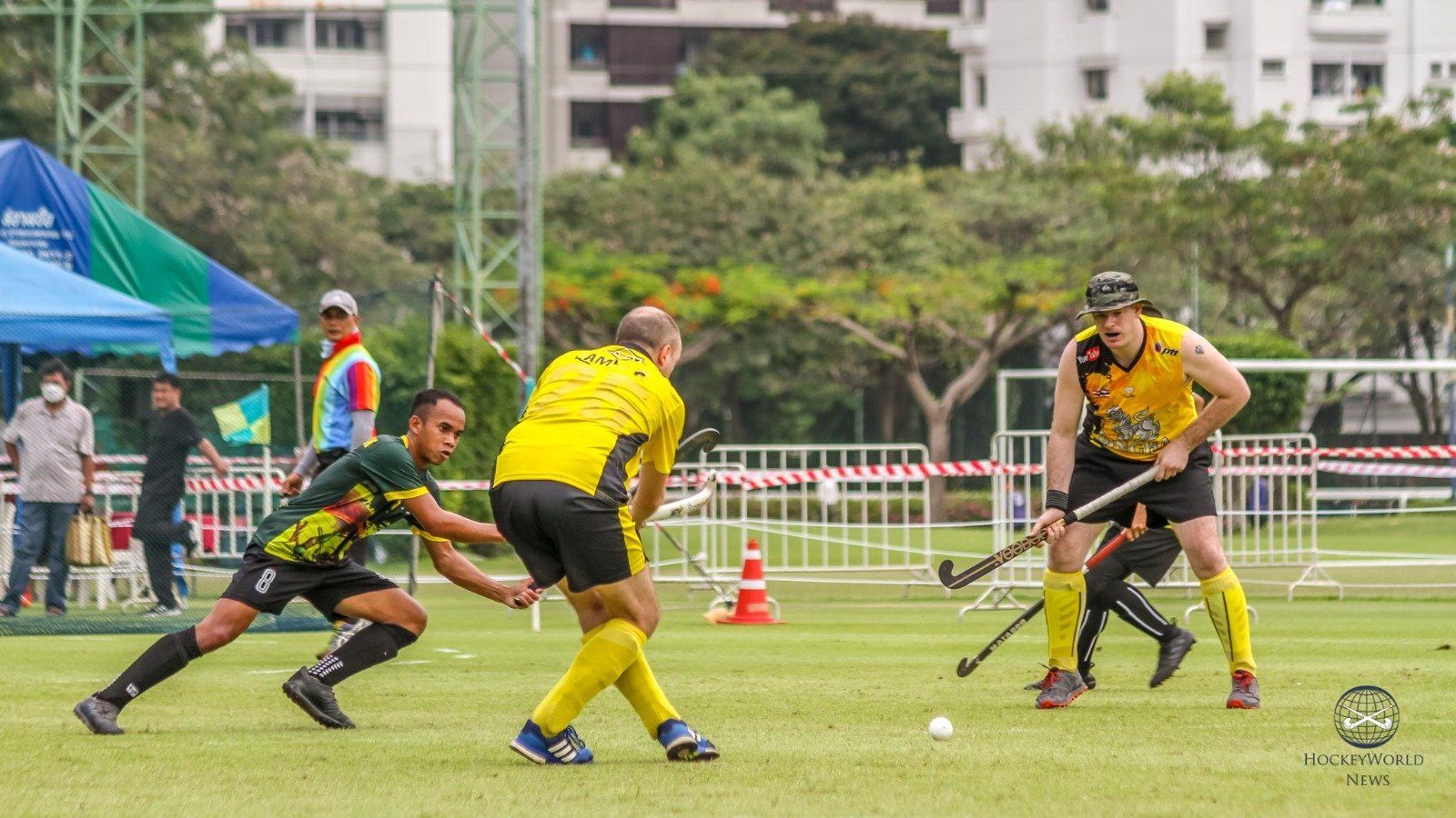 A group of men are playing field hockey on a field.