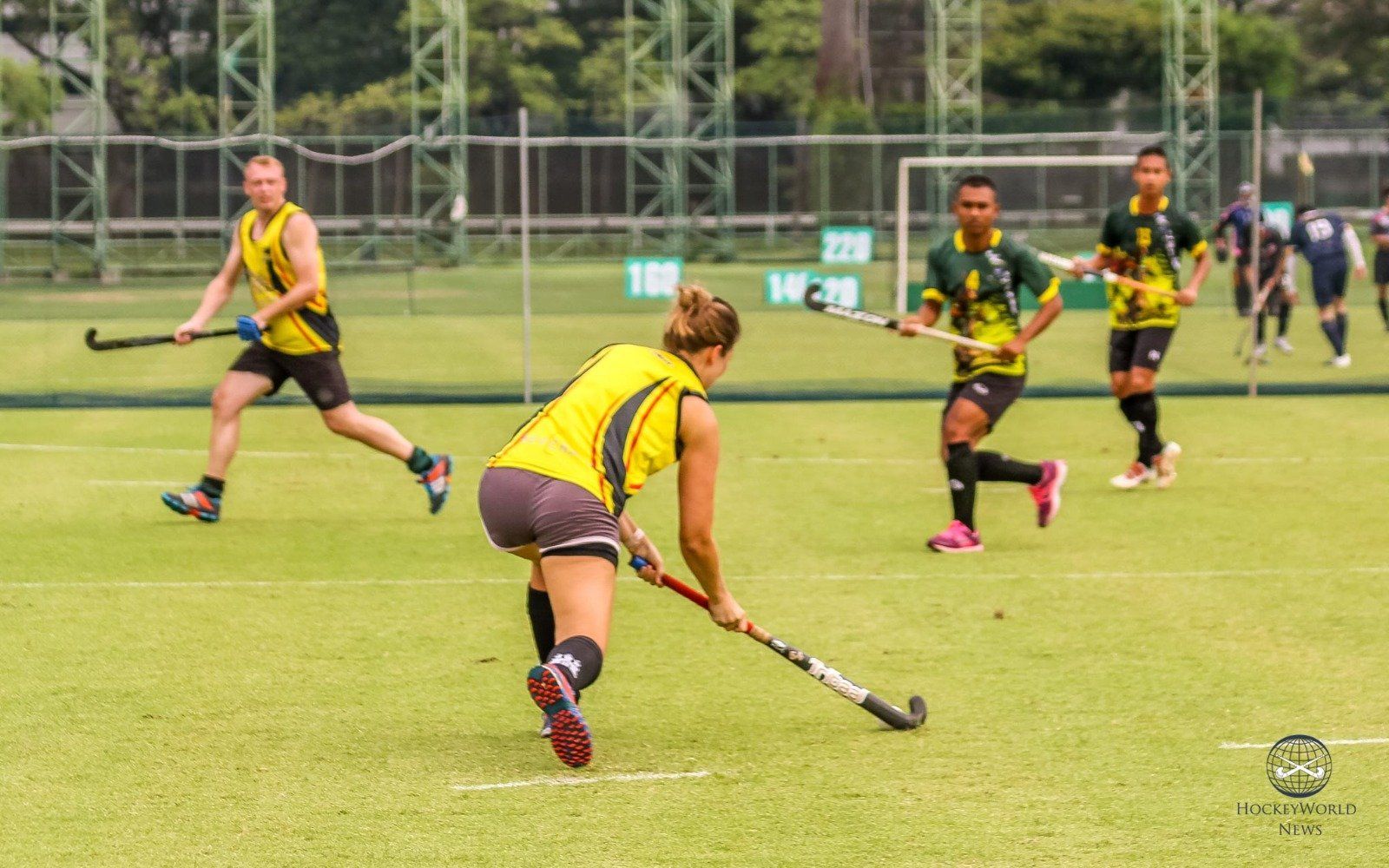A group of people are playing field hockey on a field.