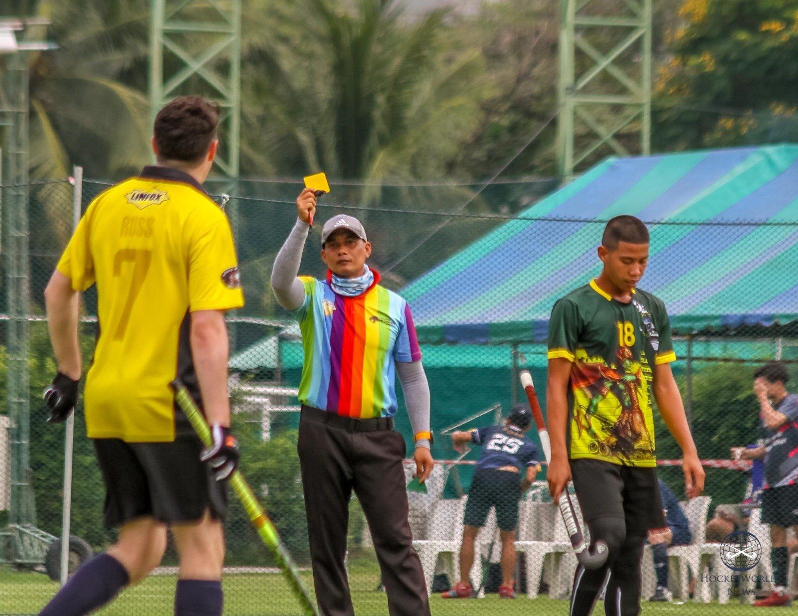 A referee is giving a yellow card to a hockey player.
