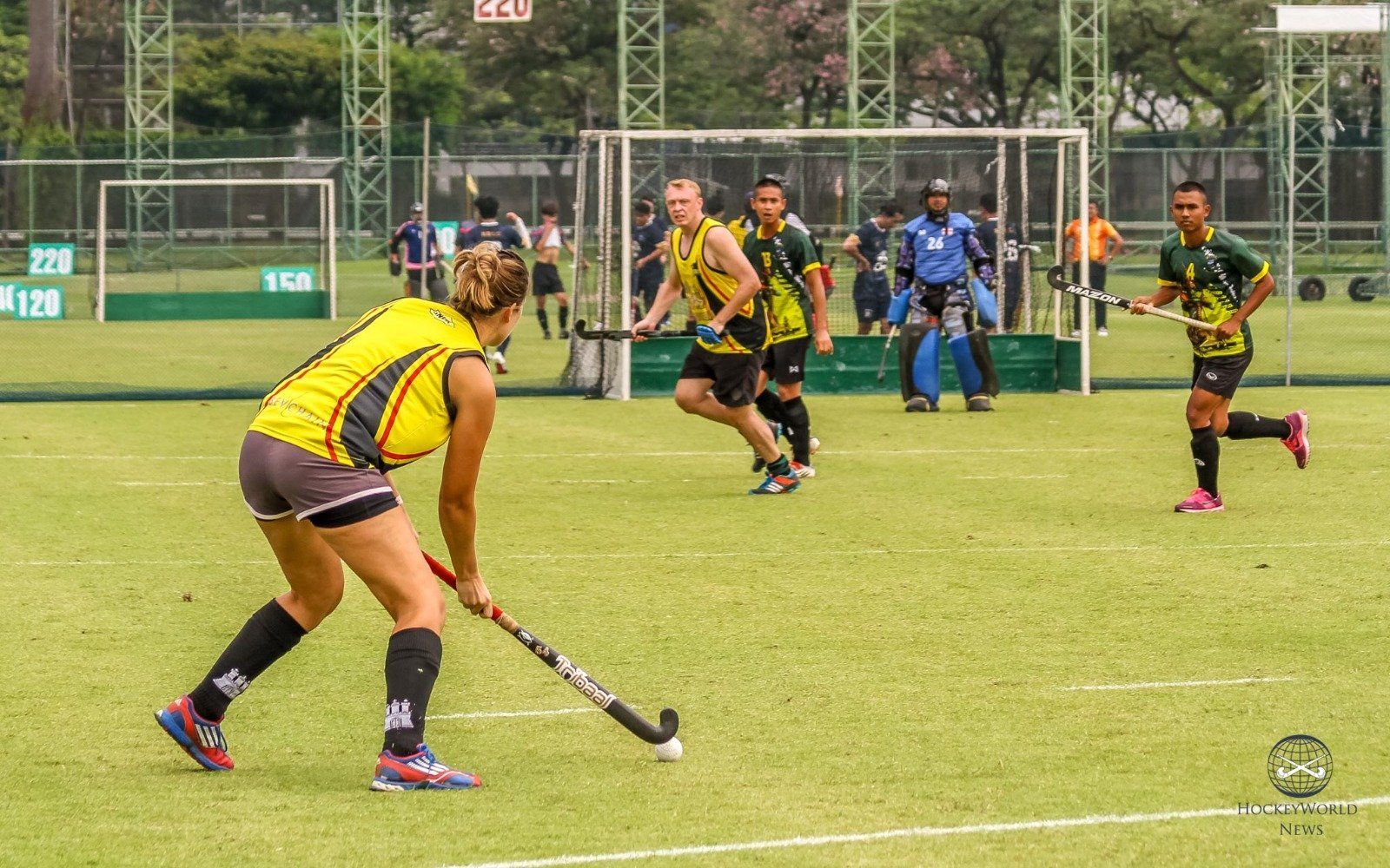 A group of people are playing field hockey on a field.