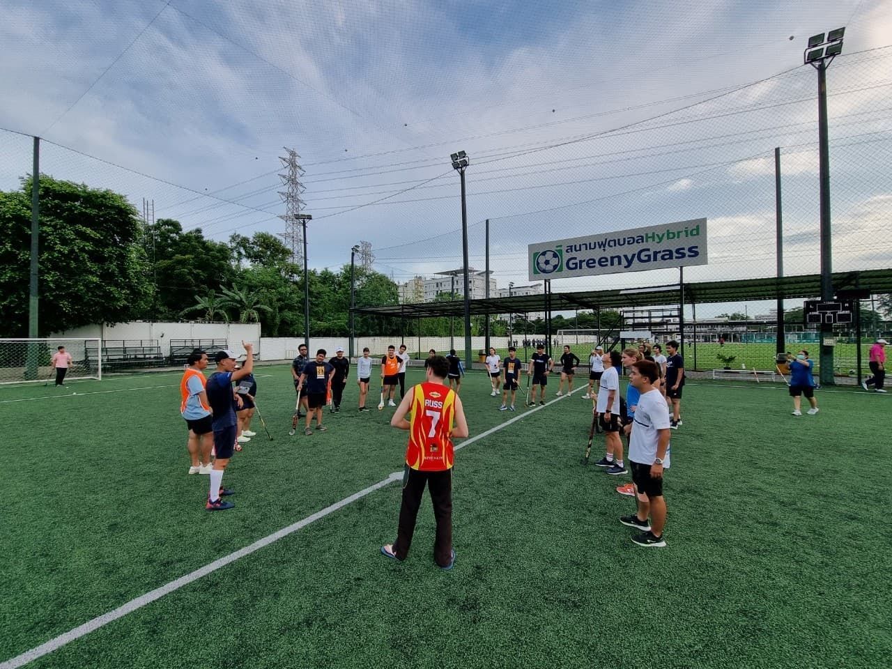 A group of people are standing on top of a soccer field.
