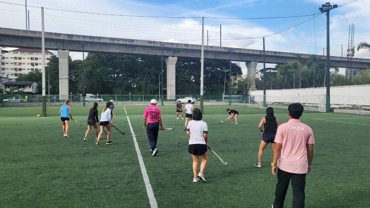 A group of people are playing lacrosse on a field.