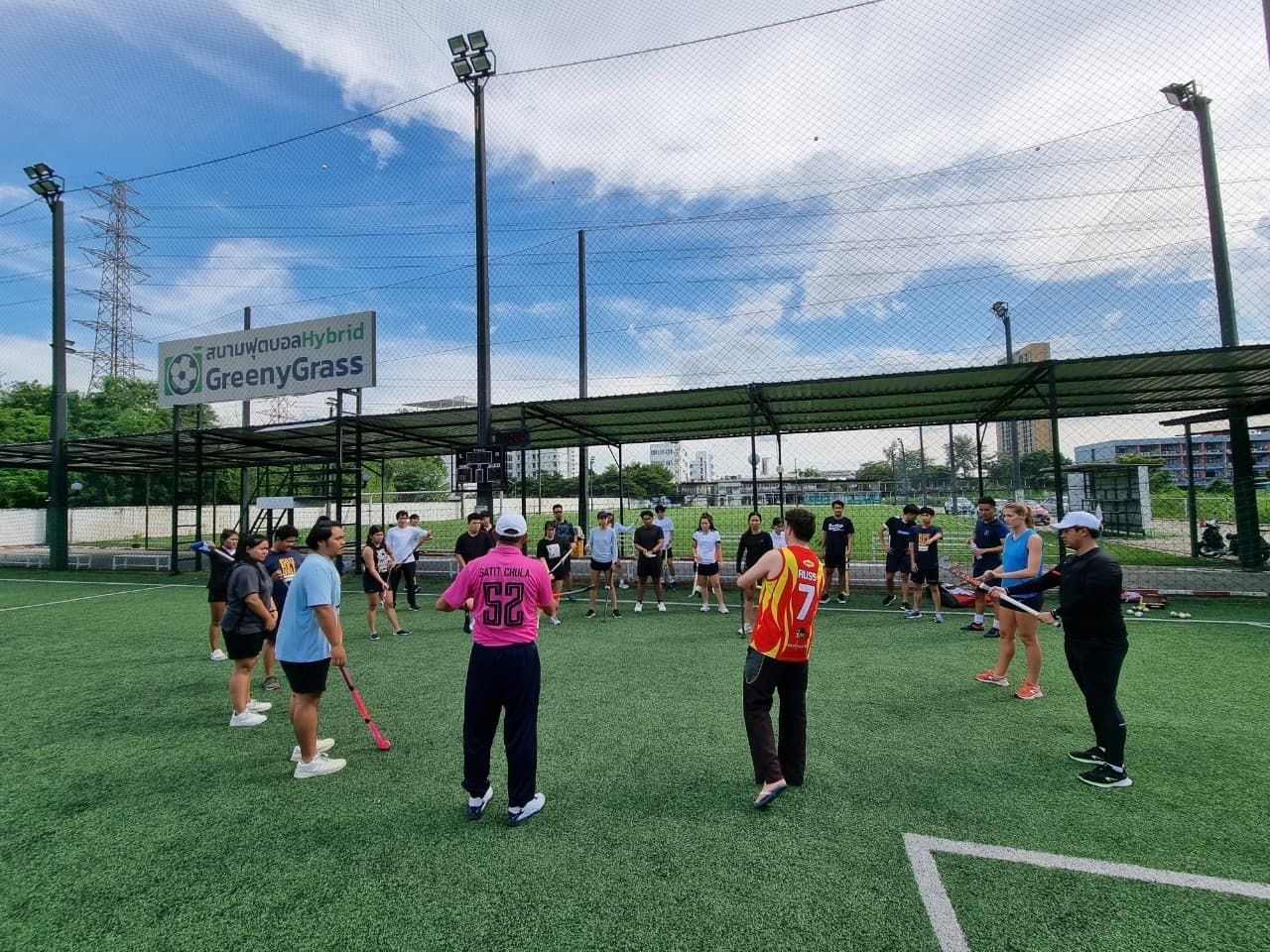 A group of people are standing on top of a soccer field.