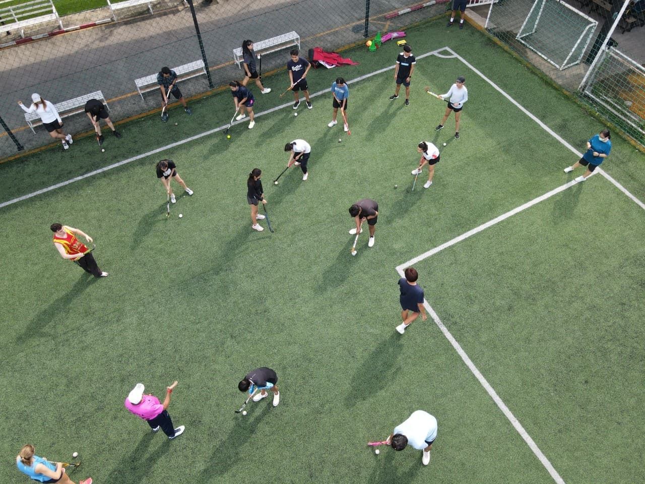 A group of people are doing stretching exercises on a soccer field.