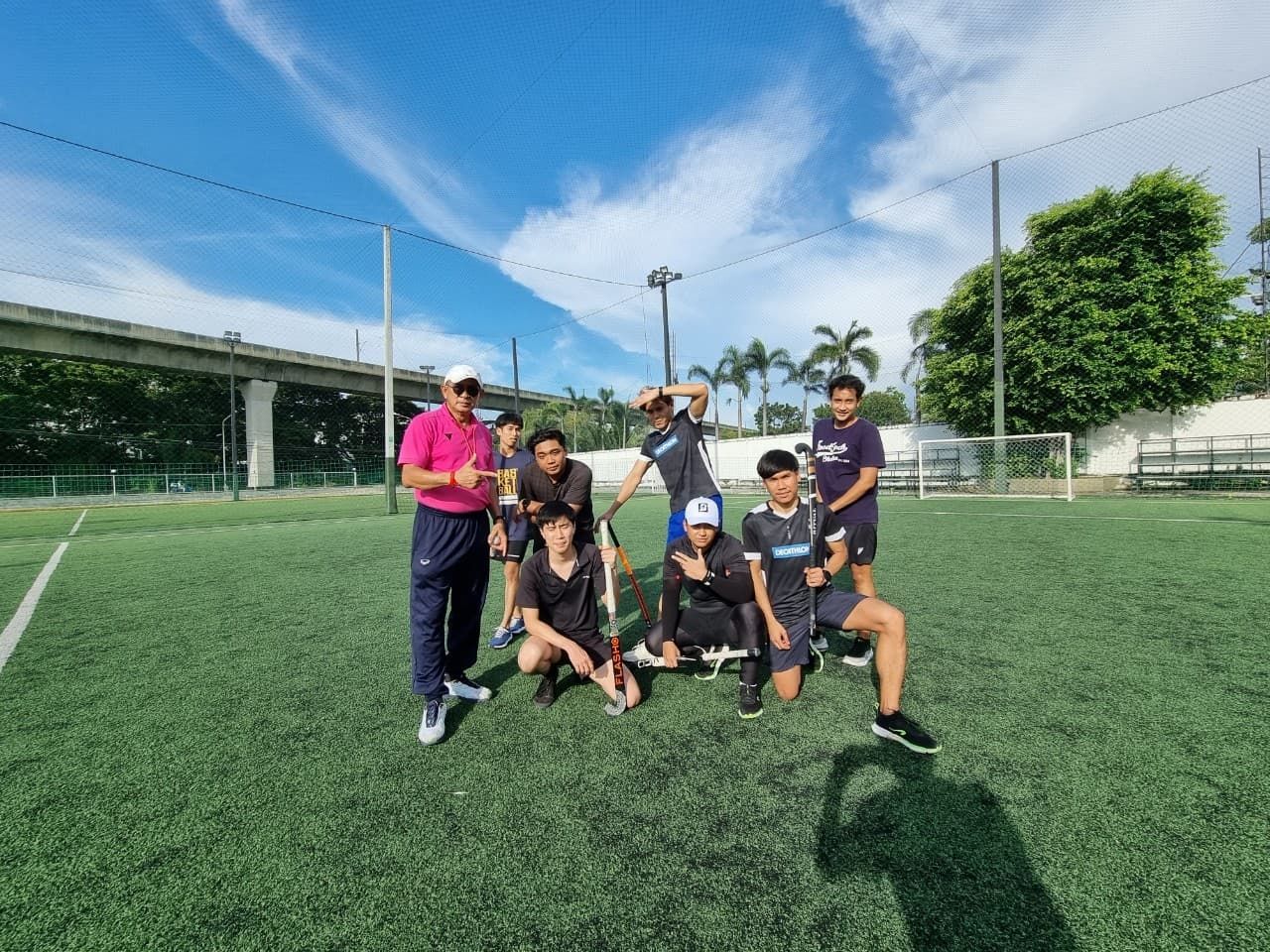 A group of people are posing for a picture on a soccer field.