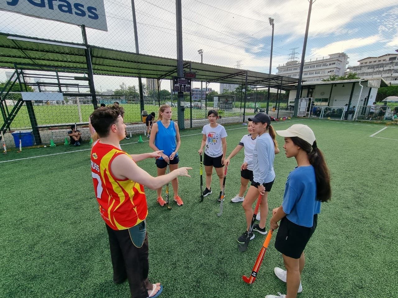 A group of people are standing in a circle on a field.