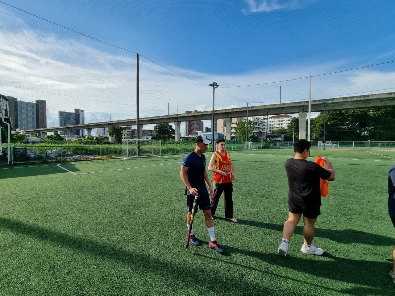 A group of people are standing on top of a soccer field.