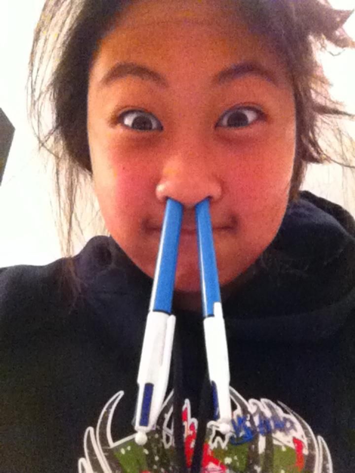 A girl with two pens sticking out of her nose