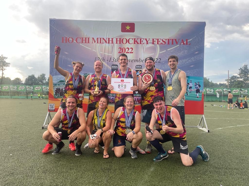A group of people are posing for a picture on a field.