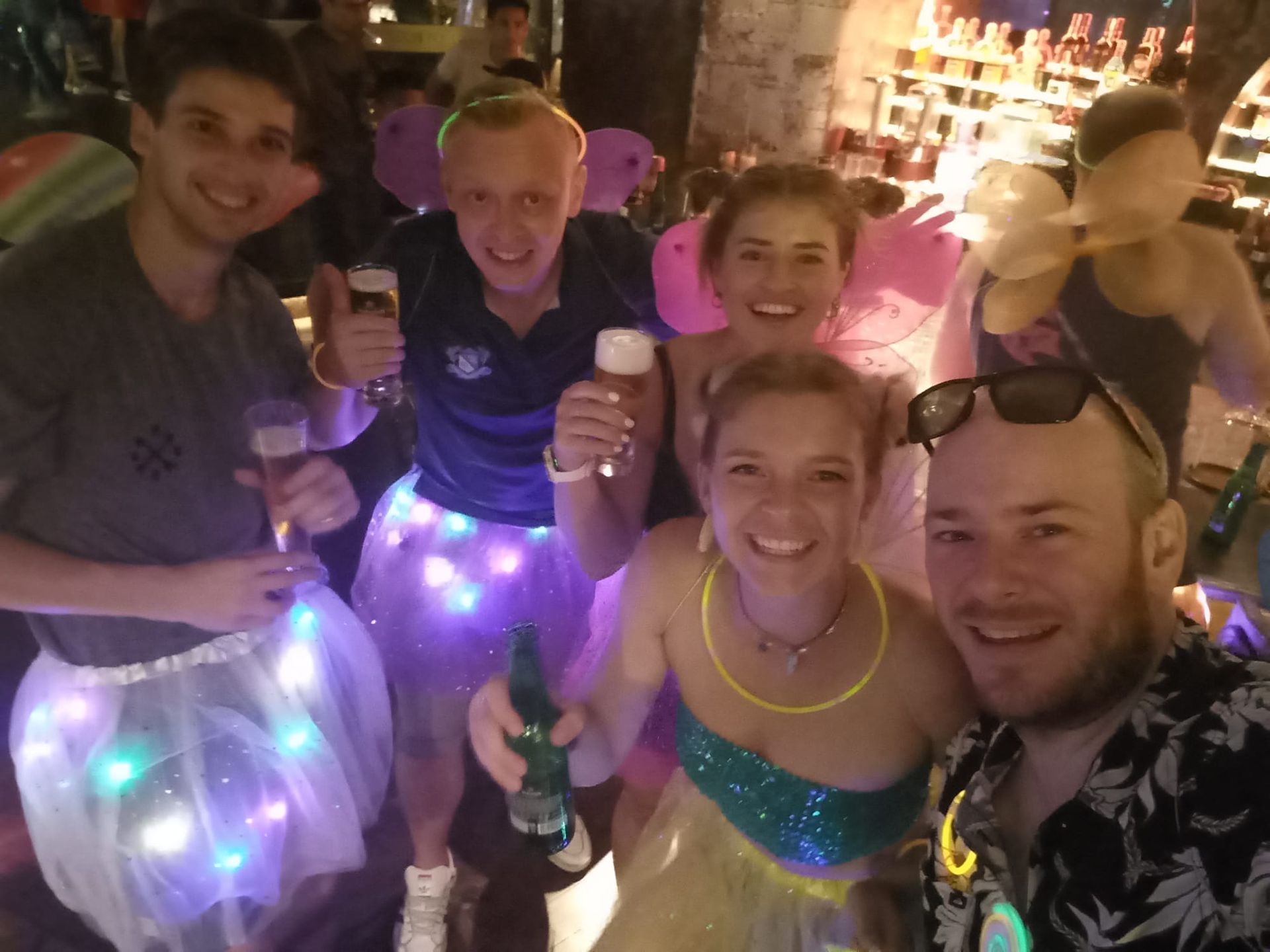 A group of people are posing for a picture in a bar