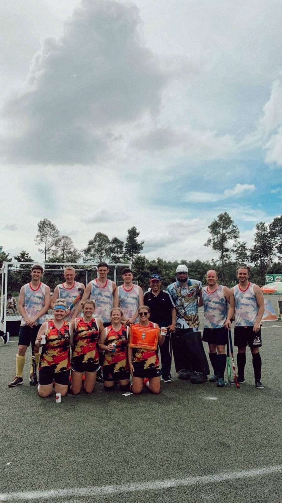 A group of people are posing for a picture on a field.