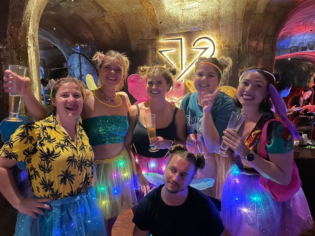 A group of people are posing for a picture in a bar.