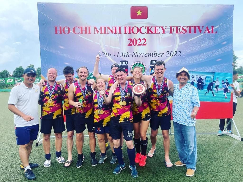 A group of people are posing for a picture on a field.