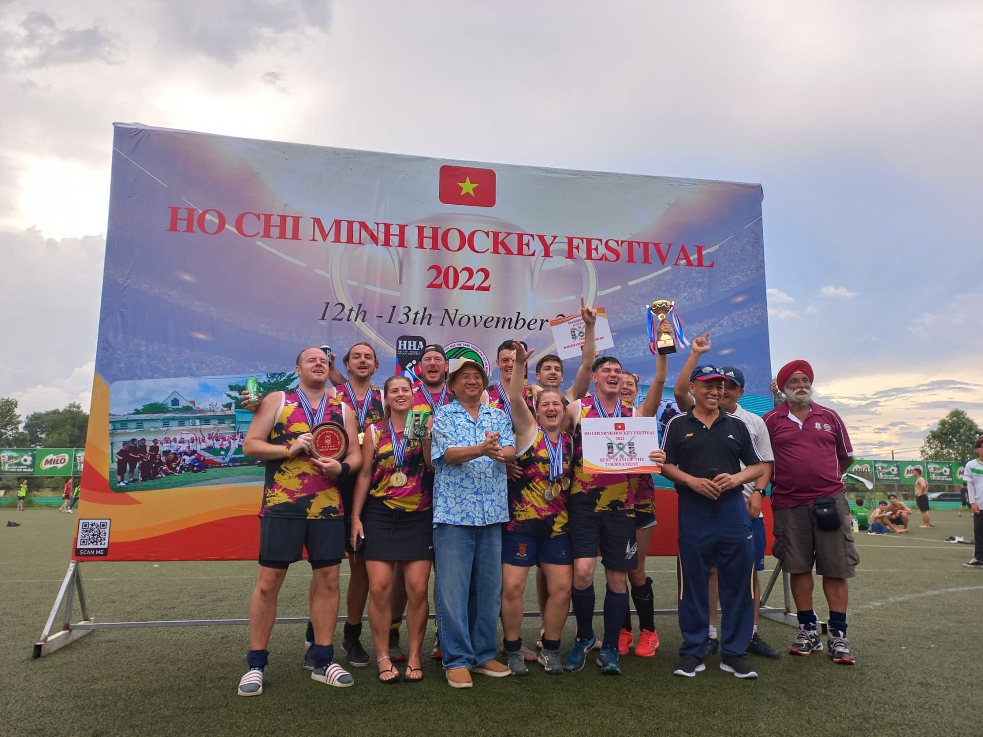 A group of people are posing for a picture on a field.