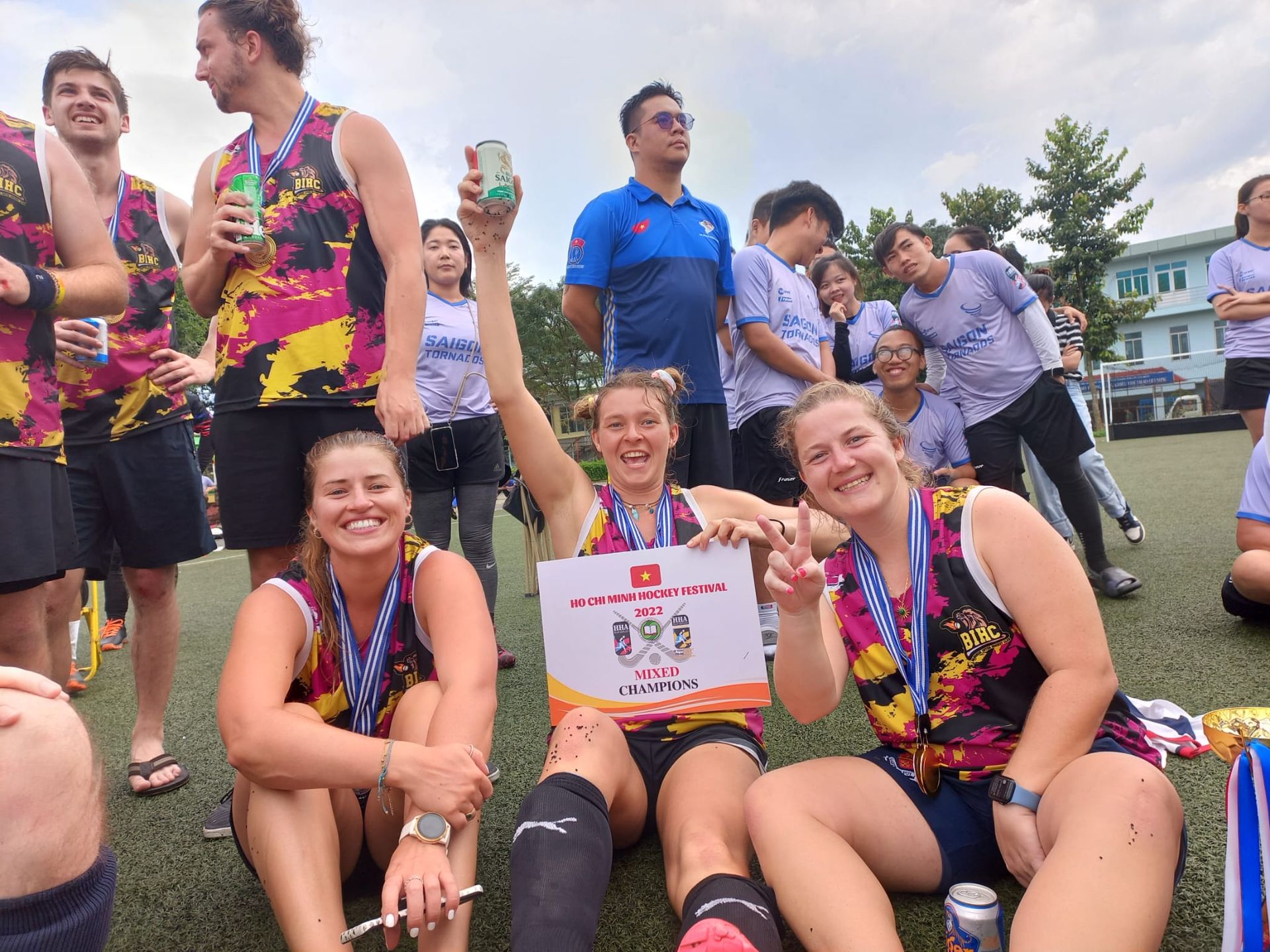 A group of people are posing for a picture on a field.