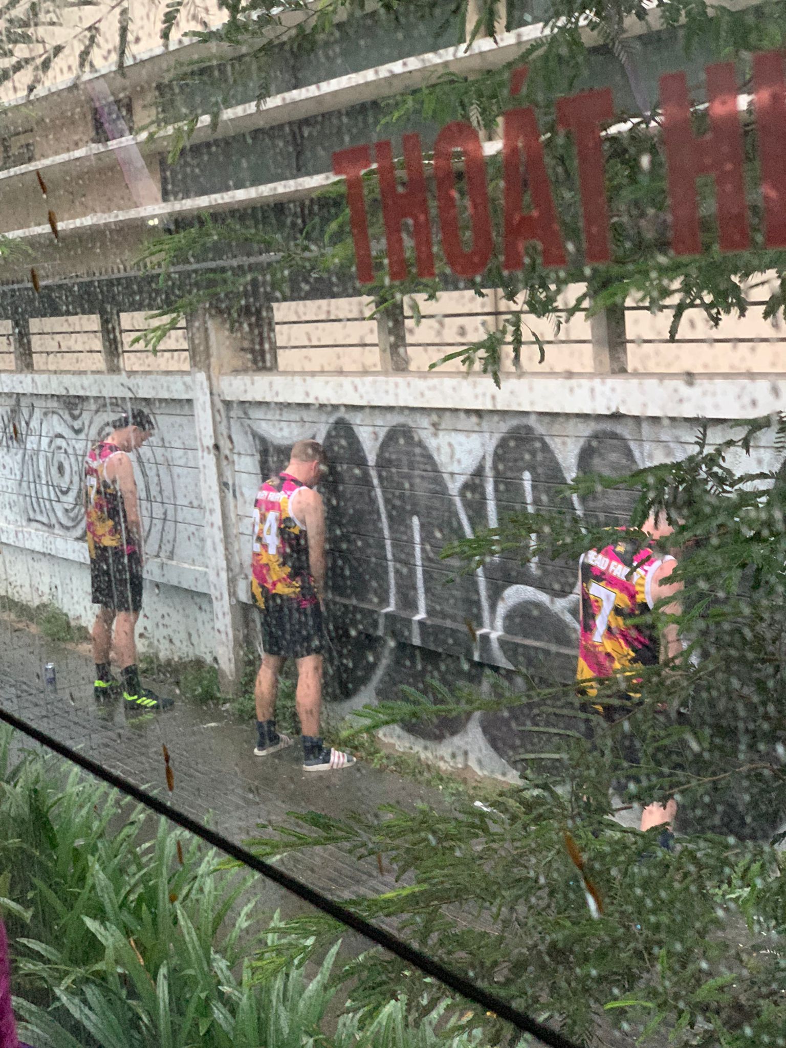 A group of people standing next to a wall with graffiti on it.