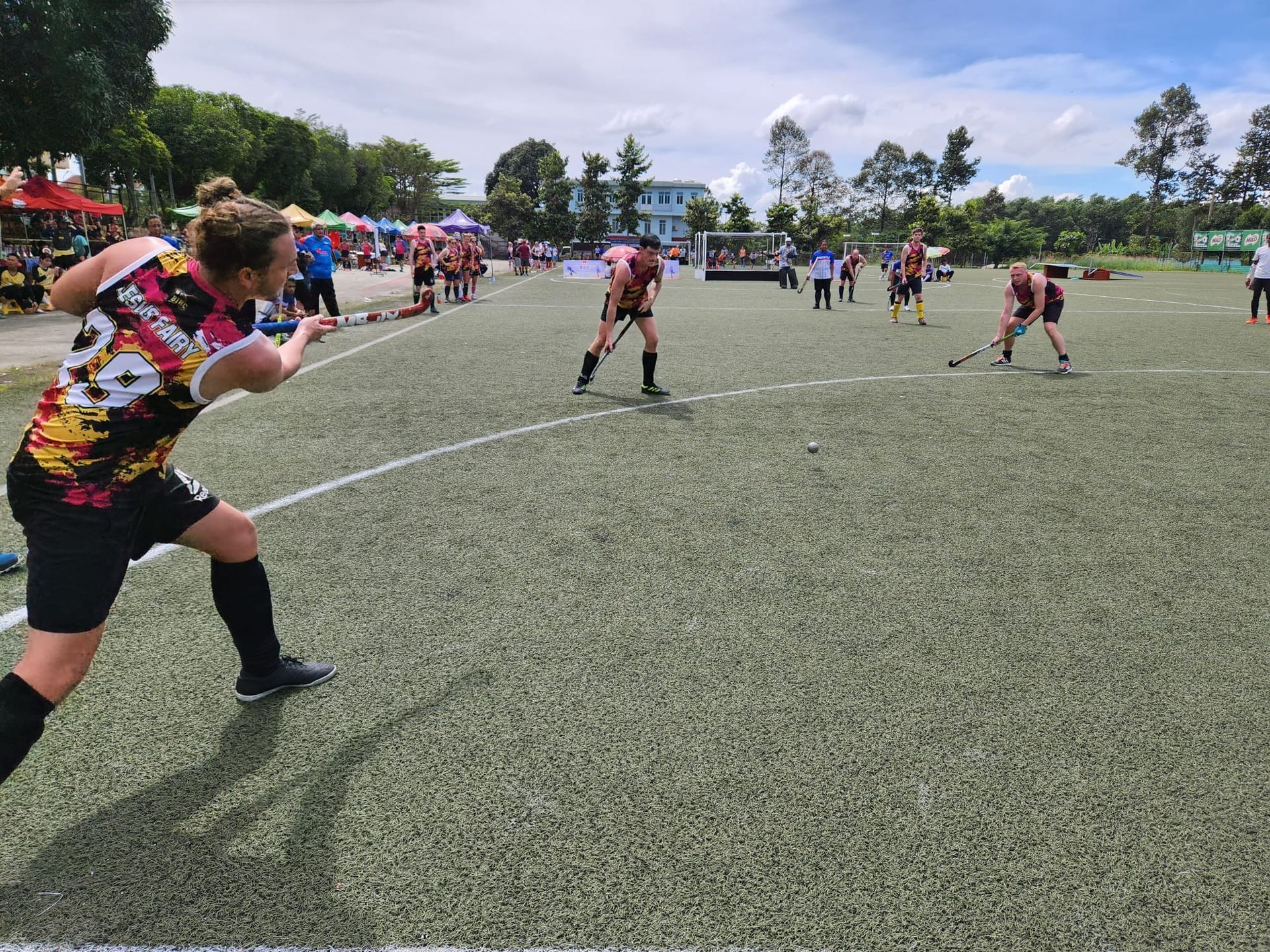 A group of people are playing field hockey on a field.