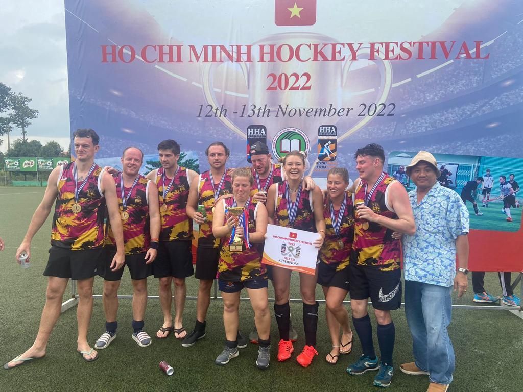 A group of people are posing for a picture on a field.